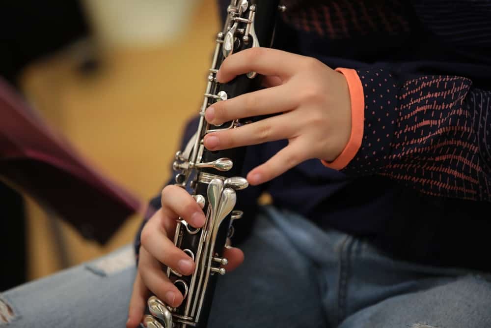 a student with braces playing the clarinet, a woodwind instrument