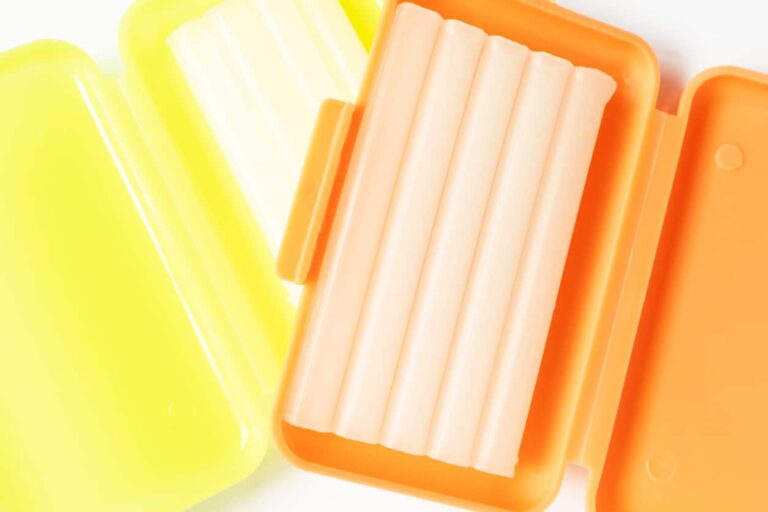 Yellow and orange dental wax inside their case stacked on top of each other