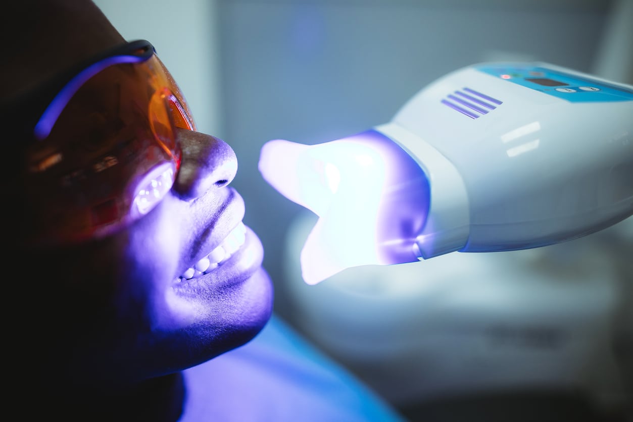 Female patient visiting dentist for teeth whitening in clinic